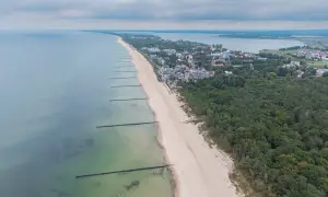 Mielno atrakcje: szeroka plaża, morze, las i zabudowania kurortu rozciągają się wzdłuż wybrzeża.
