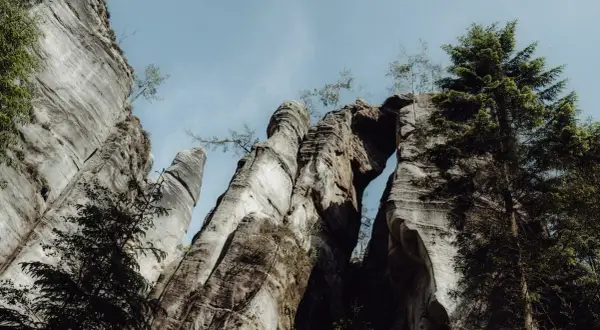 Skalne miasto z dzieckiem w tle, gdzie potężne formacje skalne tworzą naturalny łuk.