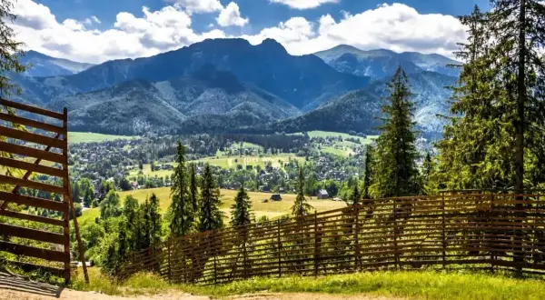 Idealne miejsce, gdzie z dzieckiem w góry. Widok na dolinę i Tatry z drewnianym płotem.