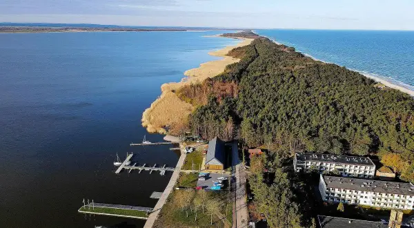 Dąbki atrakcje: malowniczy widok na jezioro, las, plażę i zabudowania. Idealne miejsce na wypoczynek.