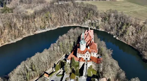Zamek Czocha, malowniczo położony nad zakolem rzeki, otoczony lasem.