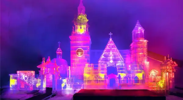 Lodowy zamek w Białce Tatrzańskiej, olśniewająca budowla z lodu, rozświetlona neonowymi barwami.
