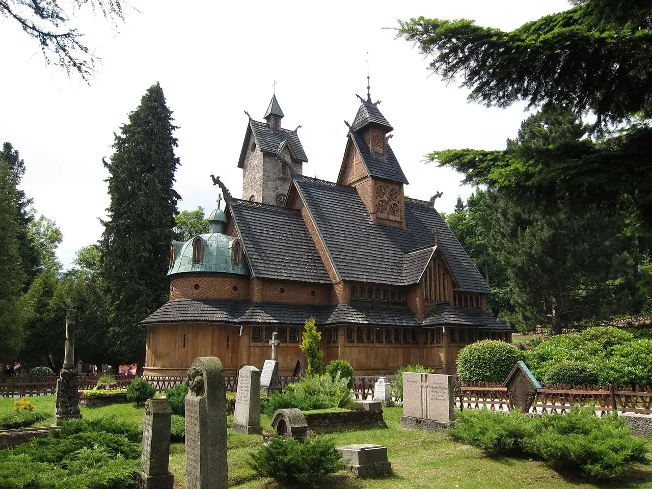 Drewniana świątynia Wang w Karpaczu, otoczona cmentarzem i drzewami. Ciekawe fakty o jej budowie i historii.
