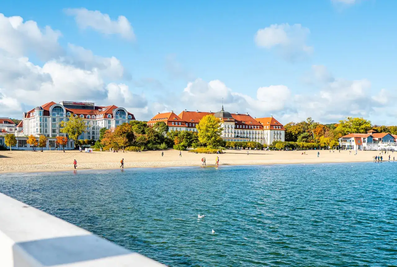Piękne miejscowości nad morzem jesienią. Hotel z czerwonym dachem, plaża i spokojne morze.