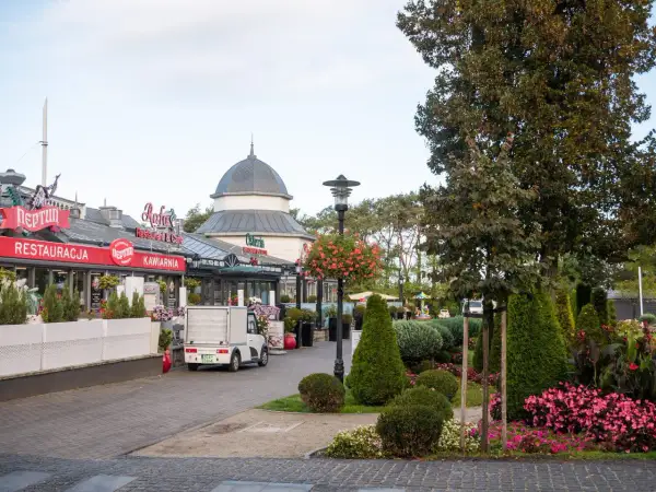 Urokliwy deptak w Międzyzdrojach, gdzie restauracje i kawiarnie zapraszają do odpoczynku. Wśród zieleni i kwiatów, to idealne miejsce na spacer i odkrywanie międzyzdrojskie atrakcje.