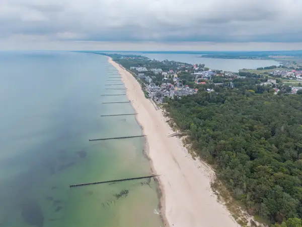 Mielno atrakcje: szeroka plaża, morze, las i zabudowania kurortu rozciągają się wzdłuż wybrzeża.